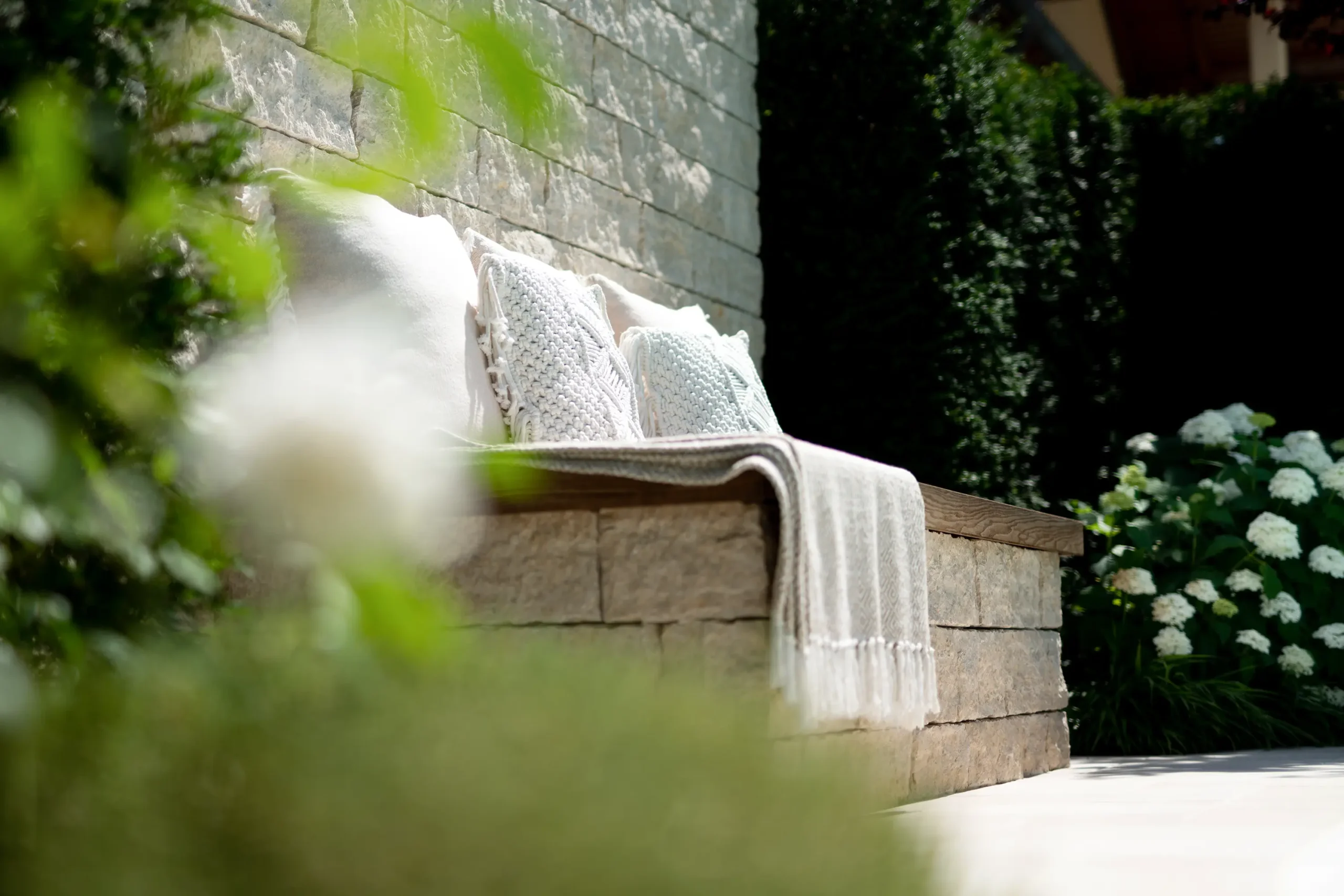 Architektur im Außenbereich mit aus Stein gebauter Bank in ruhiger Gartenumgebung