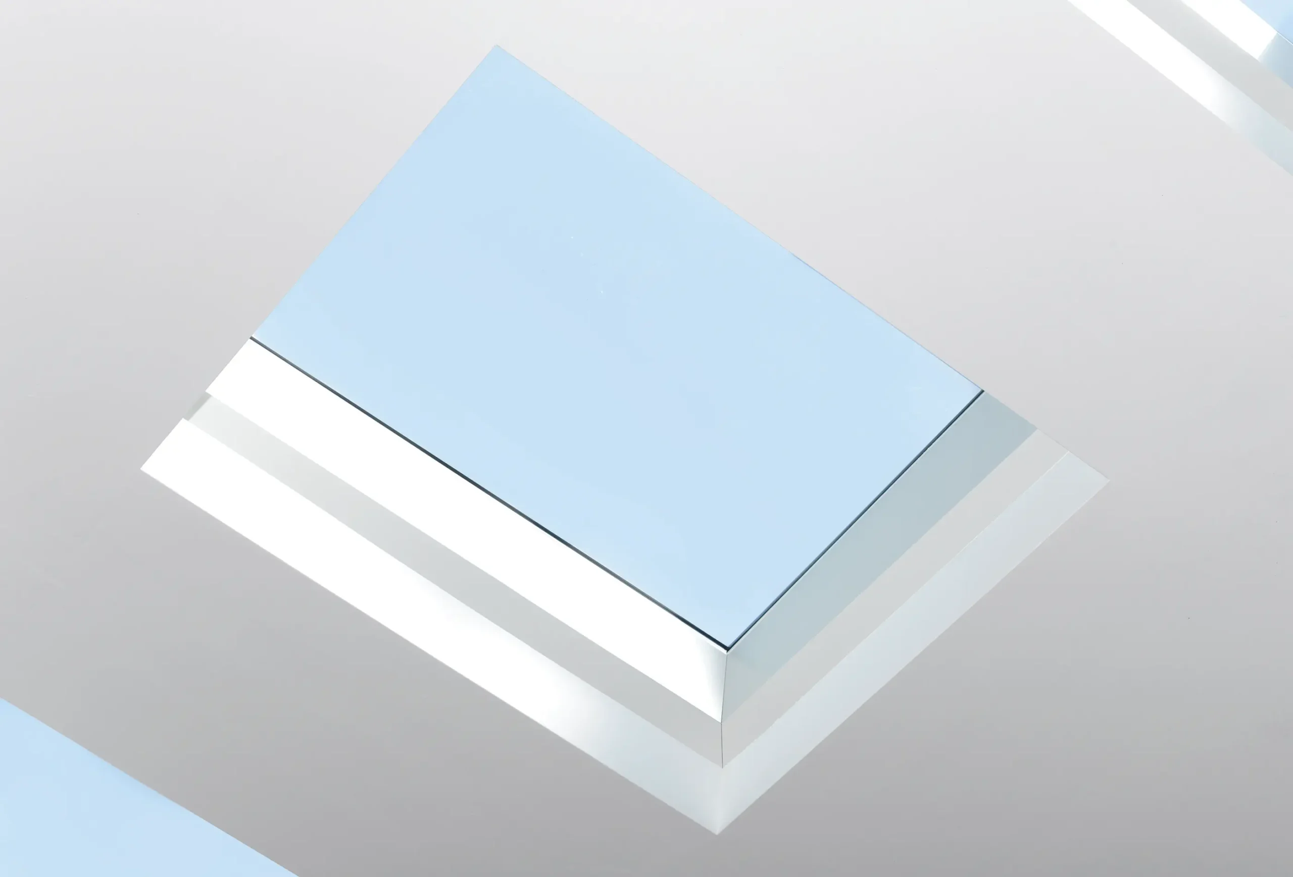 Blick von unten durch ein Dachfenster mit blauem Himmel für helle und offene Architekturfotografie