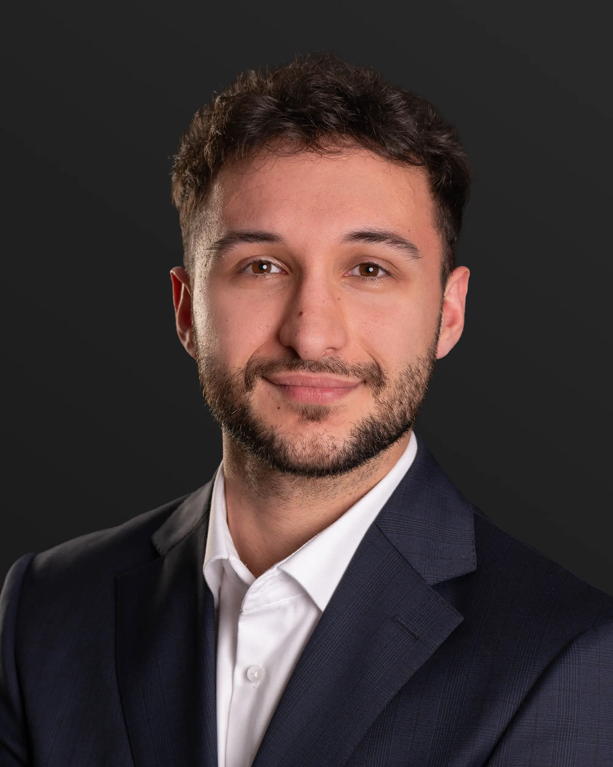 Klassisches Bewerbungsfoto mit neutralem dunklem Hintergrund und professioneller Lichtführung