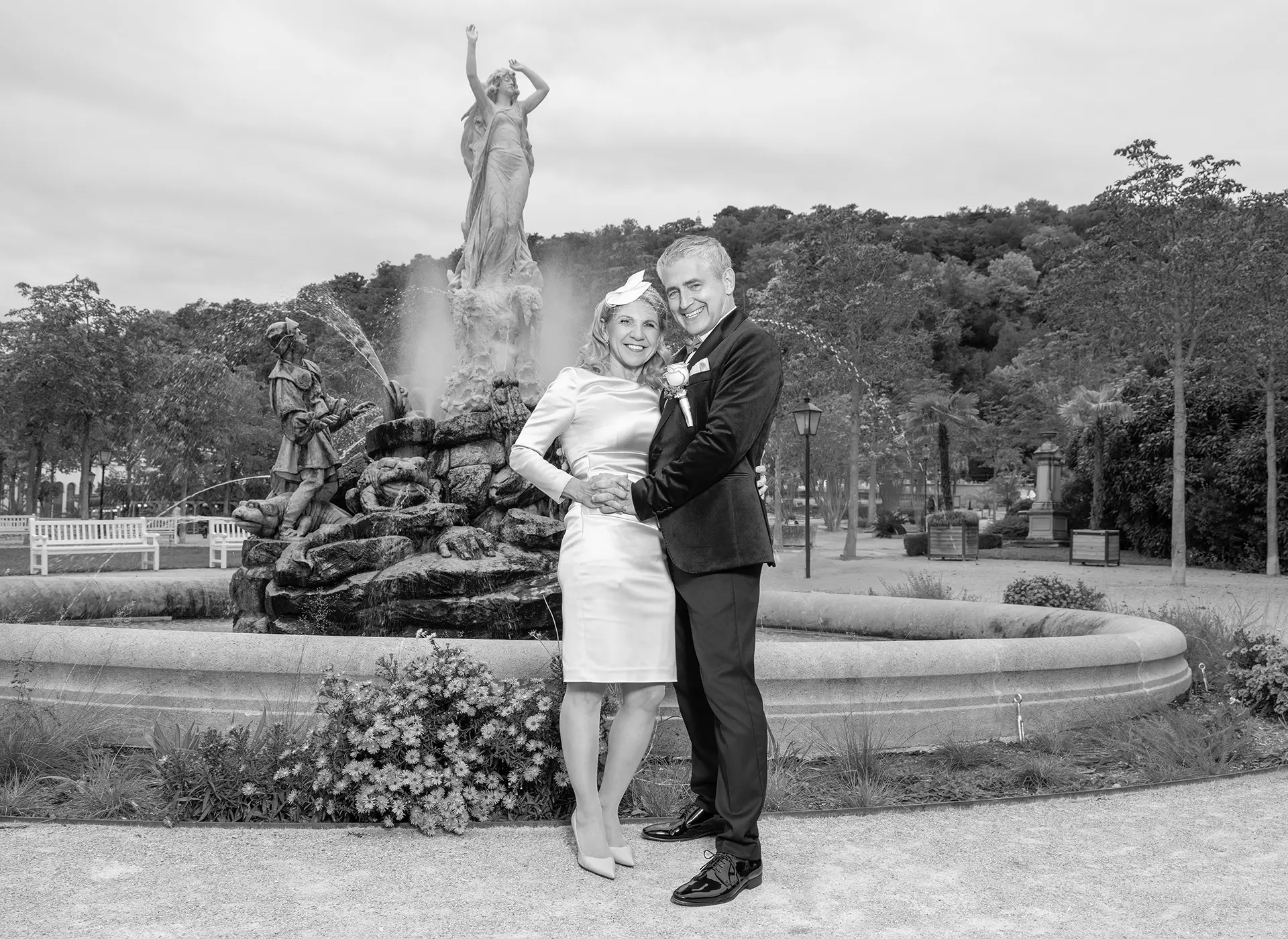 Brautpaar steht vor einem Brunnen in ruhiger und stilvoller Hochzeitsaufnahme