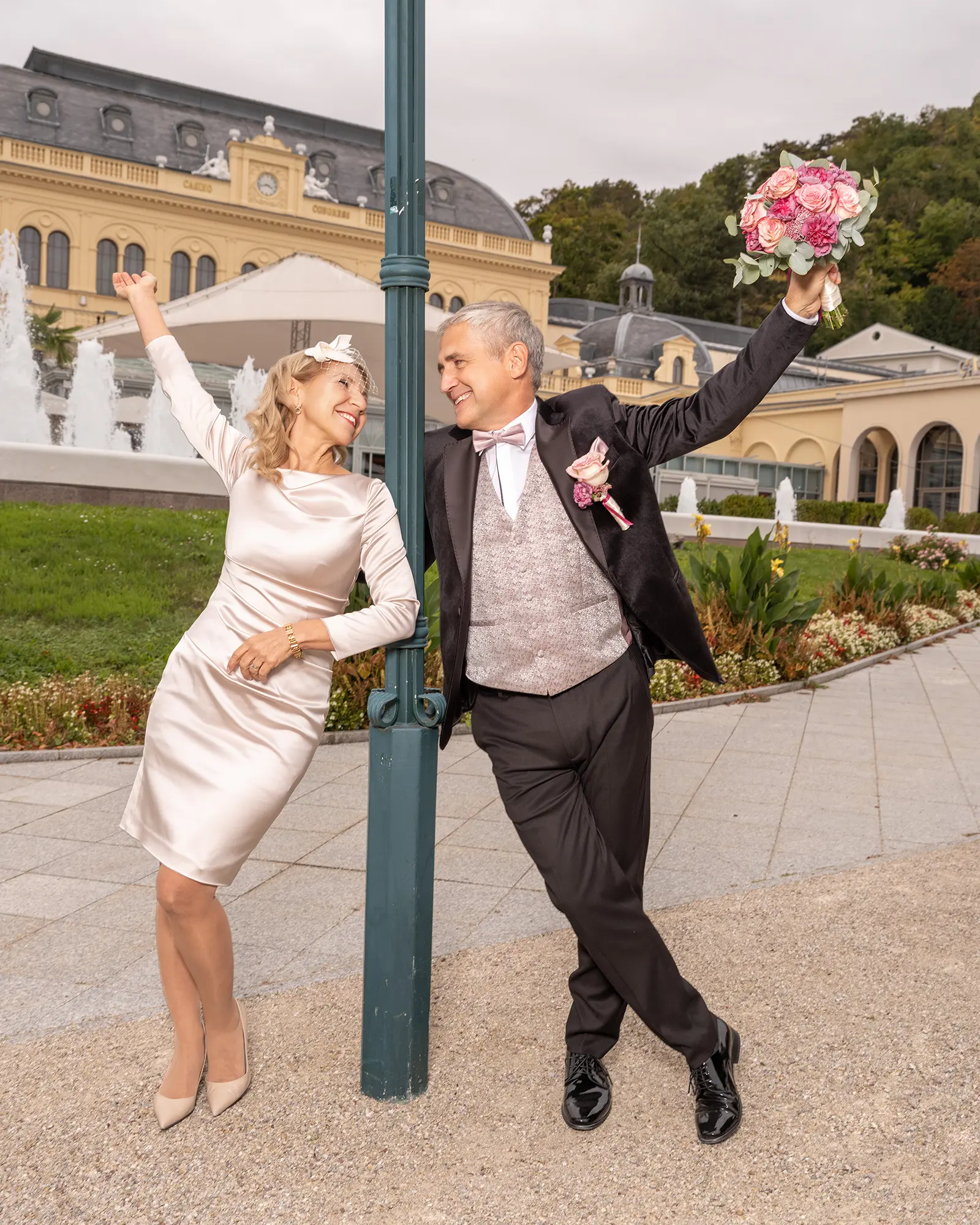Jubelndes Brautpaar mit Brautstrauß in emotionaler Hochzeitsfotografie