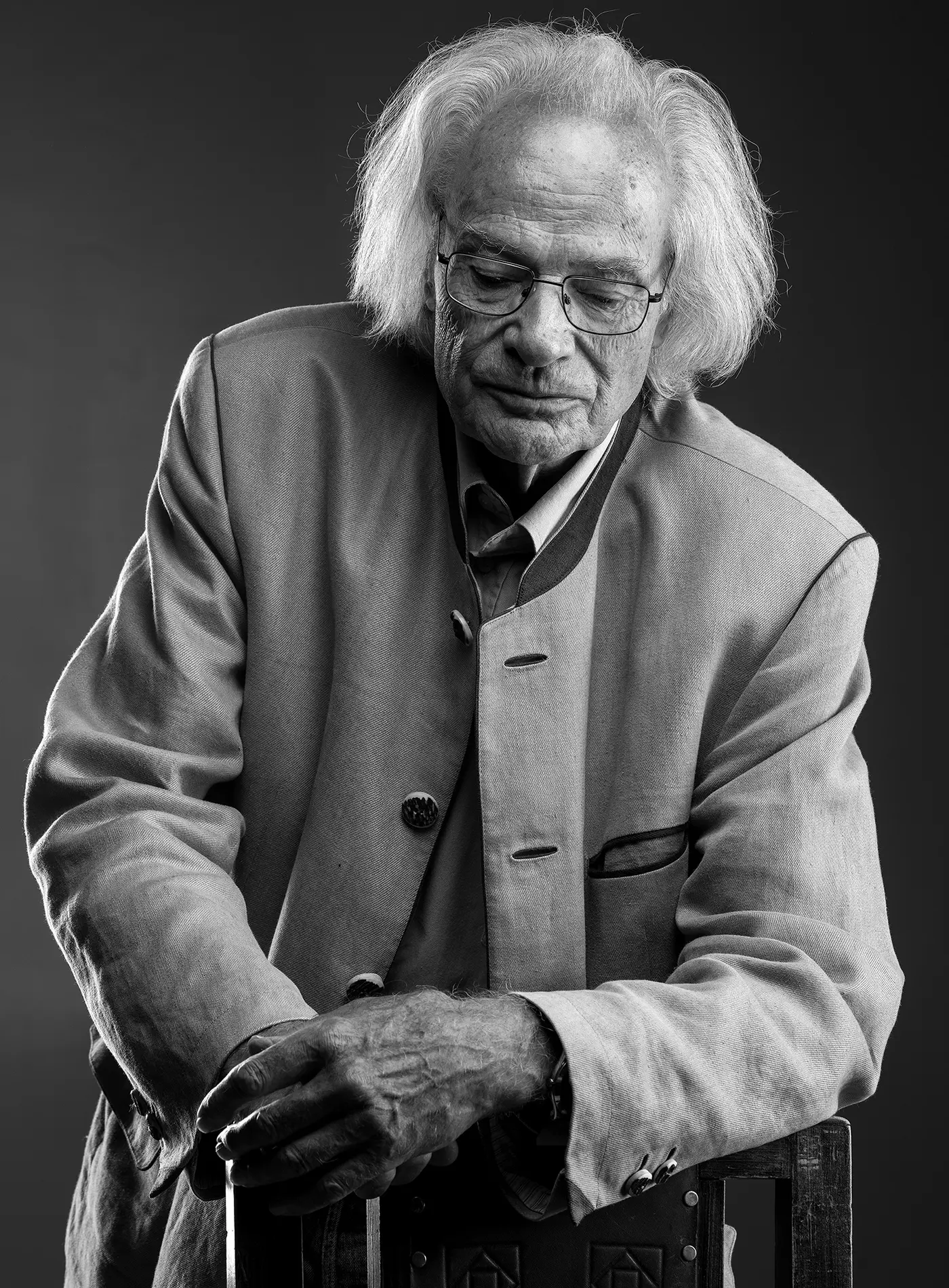 Portrait eines Mannes angelehnt an einen Stuhl mit ruhiger und nachdenklicher Ausstrahlung