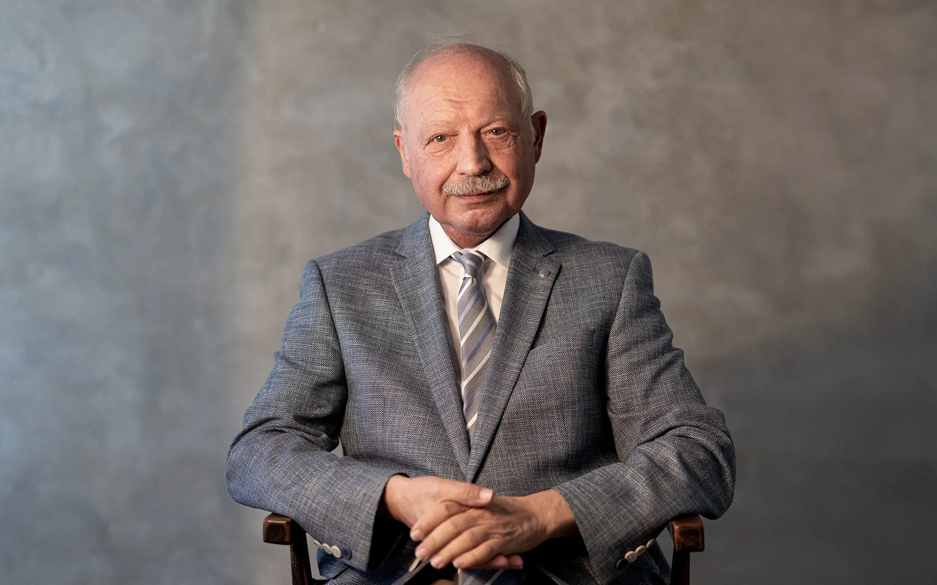 Portrait einer sitzenden Person mit viel Weißraum und minimalistischer Bildkomposition